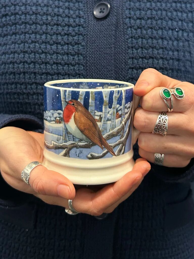 Colourful personalised Emma Bridgewater ceramic mugs and teapot with heart and polka dot designs on a tray.