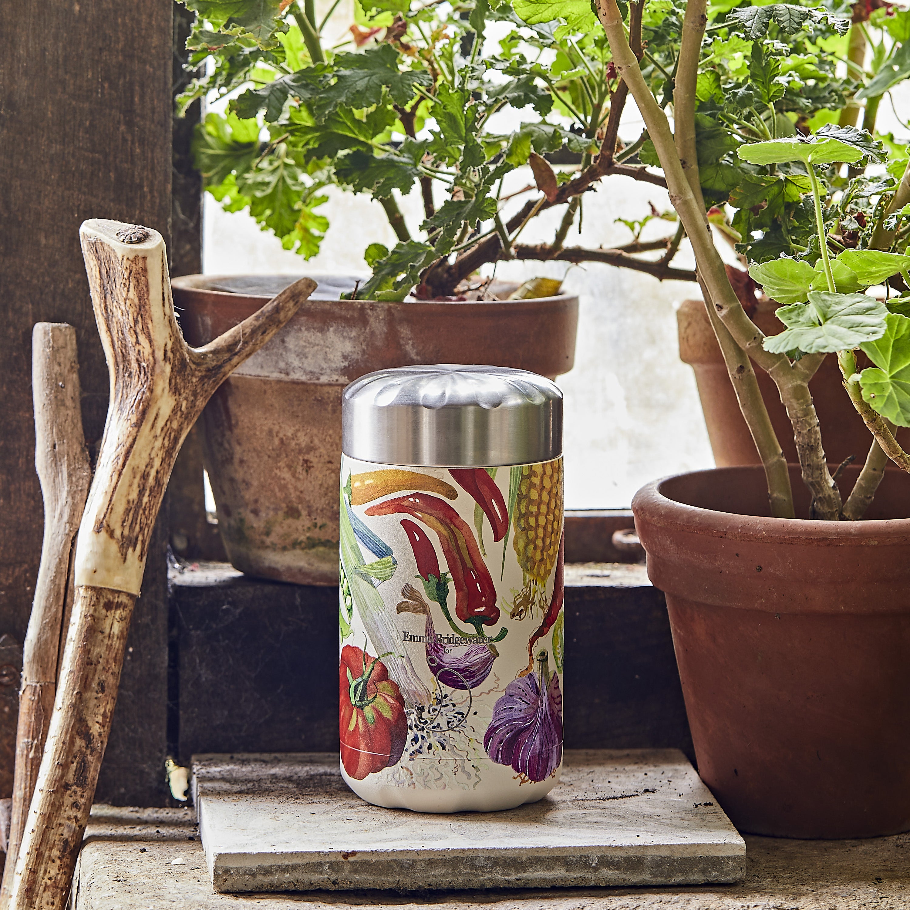 Stainless steel spice container with vibrant vegetable illustrations, offering a decorative touch to any kitchen setting.
