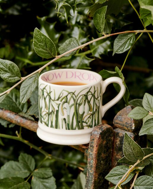Colourful personalised Emma Bridgewater ceramic mugs and teapot with heart and polka dot designs on a tray.