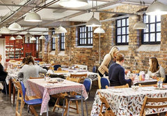 People decorating ceramic potteries in a cosy, homey decorating studio by Emma Bridgewater.